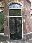 905357 Gezicht op de met siersmeedwerk gedecoreerde voordeur van het hoekpand Nieuwegracht 78 te Utrecht, met rechts de ...